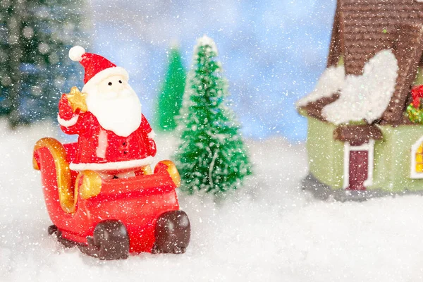 Παιχνίδι Άγιος Βασίλης και έλκηθρο στο χιόνι, τεχνητά έλατα γύρω, χριστουγεννιάτικη ευχετήρια κάρτα — Φωτογραφία Αρχείου