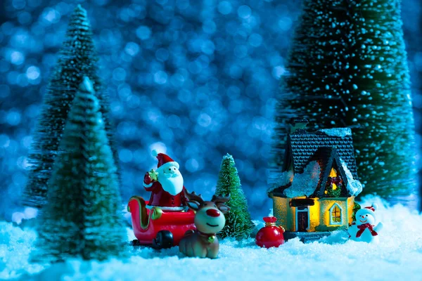 Noel Baba, köy evinin yakınındaki bir kızakta. Kar yağıyor, gece. Yeni yıl tebrik kartı, konsept