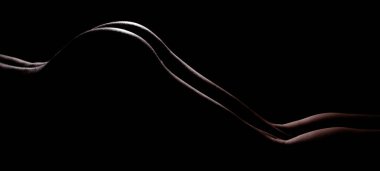 Beautiful rear view of a nude young woman in front of black studio background, her private parts are not visible