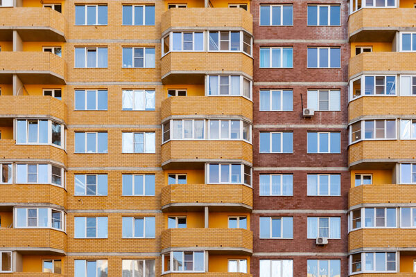 Facade of a brick apartment building with windows and balconies.