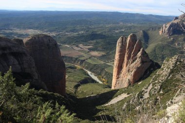 İspanya 'da Mallos de Riglos' un ünlü kaya oluşumlarının panoramik görüntüsü açık mavi bir zemin altında