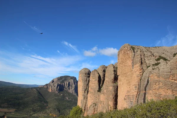 İspanya 'da Mallos de Riglos' un ünlü kaya oluşumlarının panoramik görüntüsü açık mavi bir zemin altında