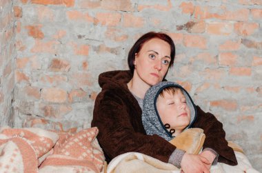 Vinnytsia. Ukrayna. 04.23.2022. Anne ve oğlu bir sığınakta saklanıyorlar. Ukrayna 'da Savaş