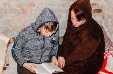 Vinnytsia. Ukrayna. 04.23.2022. Anne ve oğlu bir sığınakta saklanıyorlar. Ukrayna 'da Savaş
