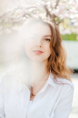 Sakura 'lı beyaz gömlekli bir kız. Bahar.