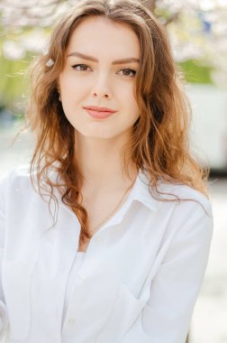 Sakura 'lı beyaz gömlekli bir kız. Bahar.