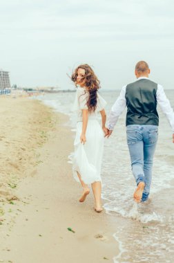 Karı koca deniz kıyısında koşuyorlar.