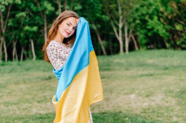 Ukrayna bayrağı taşıyan Ukraynalı kadın. Ukrayna bayrağı taşıyan kız. Ukrayna bayrağı. Ukrayna. Ukrayna 'nın mavi ve sarı bayrağı olan bir kızın vatansever fotoğrafı.
