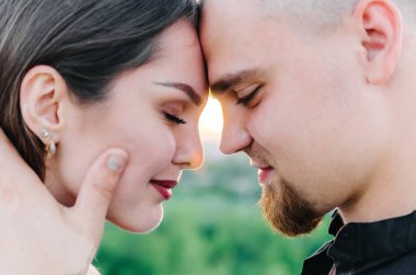 Kadın ve erkek kapalı gözlerle birbirlerinin alınlarına dokunurlar.