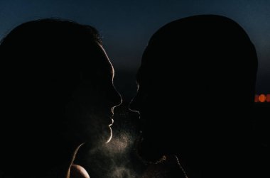 Geceleri su sıçratan kadın ve erkeğin silueti.