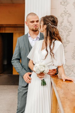 Gelin ve damat kayıt bürosunun korkuluklarında duruyorlar.