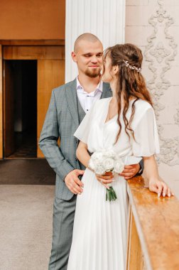 Gelin ve damat kayıt bürosunun korkuluklarında duruyorlar.