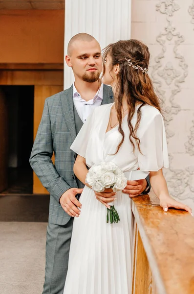 Gelin ve damat kayıt bürosunun korkuluklarında duruyorlar.