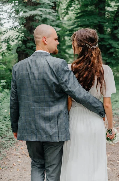 Damat gelinin beline sarılır.