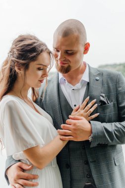 Gelinler el ele tutuşup nazikçe sarılırlar.