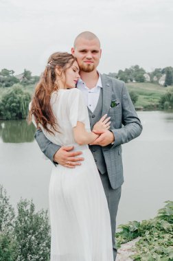 Gelinler gölün arka planında sarılıyor