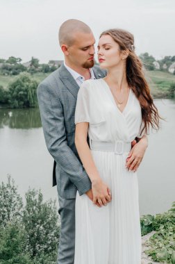 Gelinler gölün arka planında sarılıyor