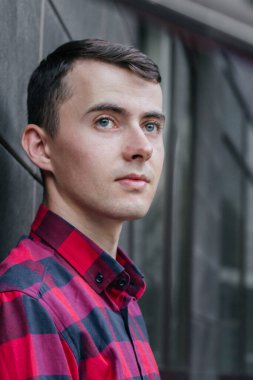 Kırmızı kareli gömlekli bir adamın portresi.