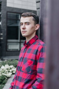 Kırmızı kareli gömlekli genç yakışıklı adam.