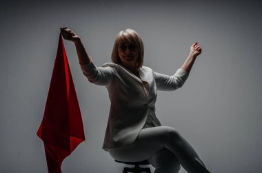 a woman in a white suit with a red scarf on a white background