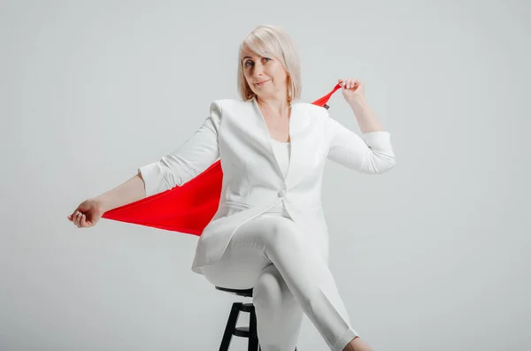 a woman in a white suit with a red scarf on a white background