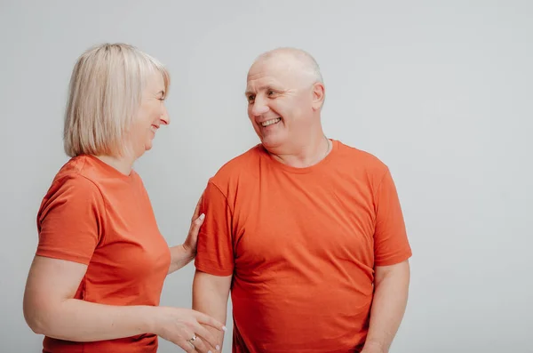 man and woman in orange t-shirts on a white background