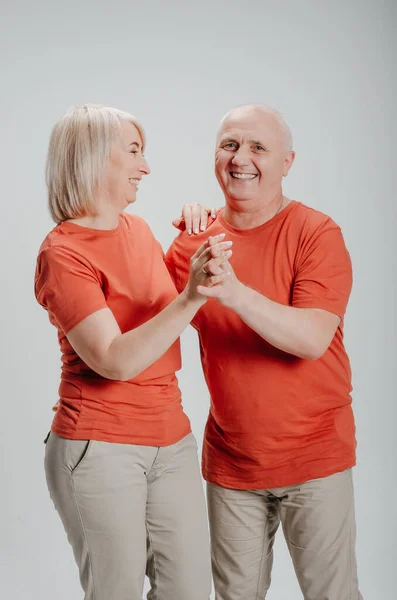 man and woman in orange t-shirts on a white background