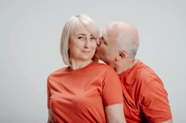 couple in love in orange t-shirts on a white background