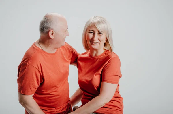 couple in love in orange t-shirts on a white background