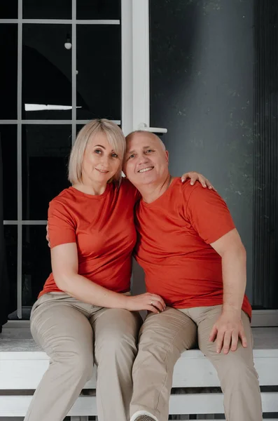 husband and wife in orange t-shirts hug and kiss