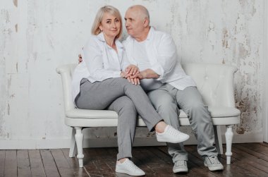 Beyaz gömlekli bir adam ve karısı fotoğraf stüdyosunda.