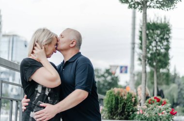 a man and his wife in black T-shirts are hugging in the city