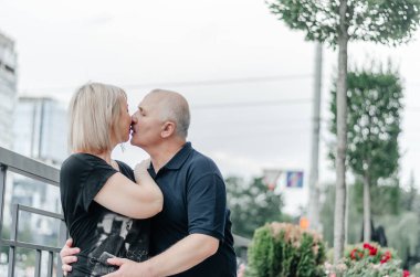 a man and his wife in black T-shirts are hugging in the city