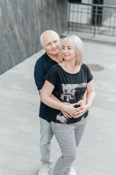 man and woman in dark t-shirts on the street