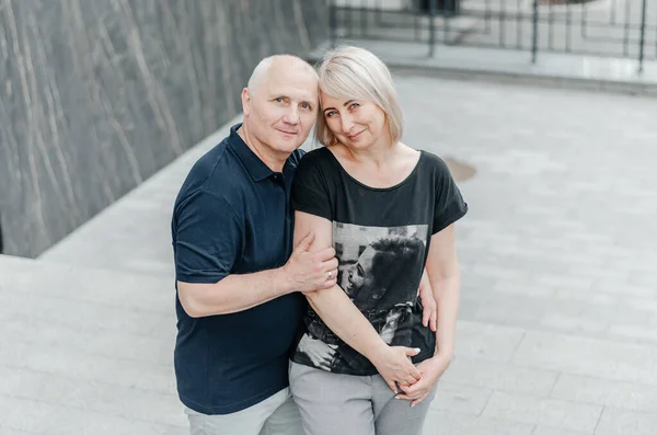 man and woman in dark t-shirts on the street