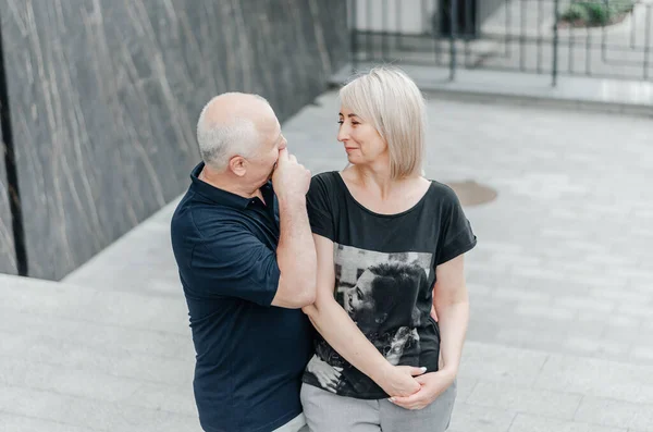 man and woman in dark t-shirts on the street