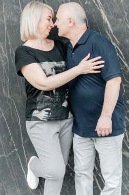 a man and his wife in dark T-shirts and gray pants