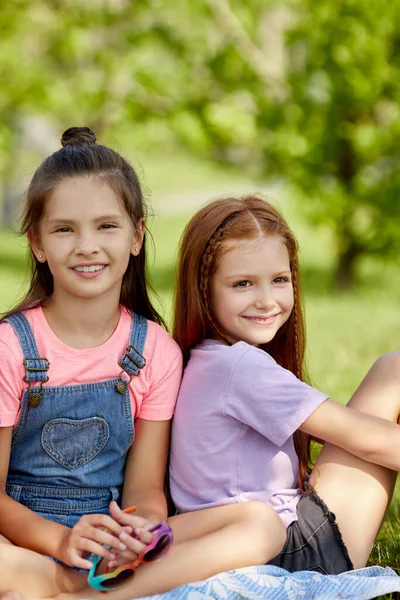 Gelukkig schattig kleine meisjes zitten samen in het park. — Stockfoto