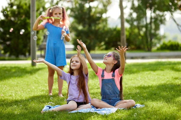 Kinderen spelen met zeepbellen in het park — Stockfoto