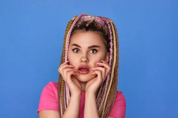 Mujer sorprendida con rastas sobre fondo azul. — Foto de Stock