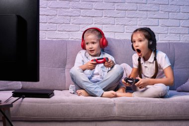 Oyun konsoluyla oyun oynayan çocuklar