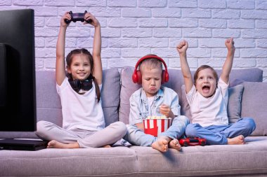 Oyun konsoluyla oyun oynayan çocuklar