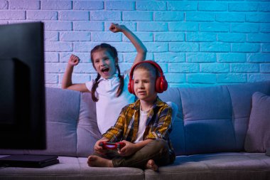 Oyun konsoluyla oyun oynayan çocuklar