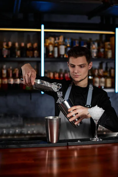 Barman coloca os cubos de gelo em um copo — Fotografia de Stock