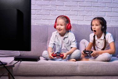 Oyun konsoluyla oyun oynayan çocuklar