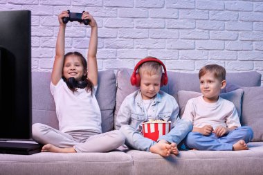 Oyun konsoluyla oyun oynayan çocuklar