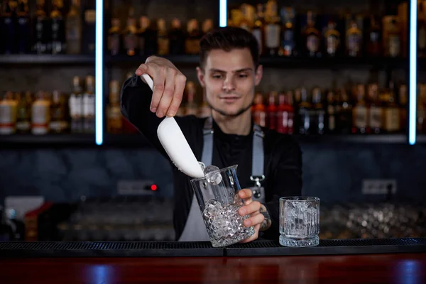 Barman wkłada kostki lodu do szklanki. — Zdjęcie stockowe