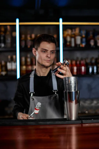 Bartender dalam celemek menambahkan bahan untuk shaker — Stok Foto