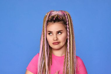 Mavi arka planda rastalı saçları olan şüpheli kadın..