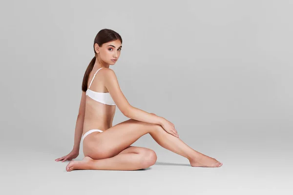 Kobieta z idealnym ciałem i nogami w białej bieliźnie — Zdjęcie stockowe